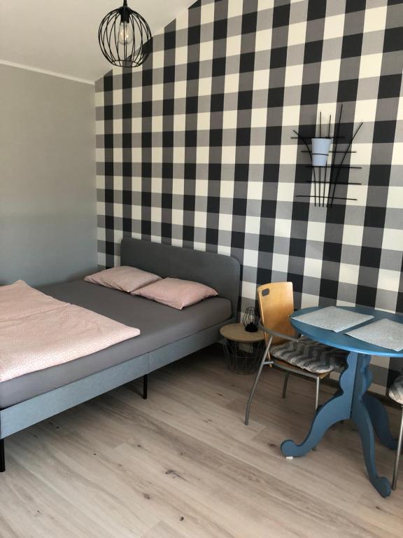 um pequeno quarto com uma cama e uma mesa em Uniejów PORT pod Sosnami em Uniejow