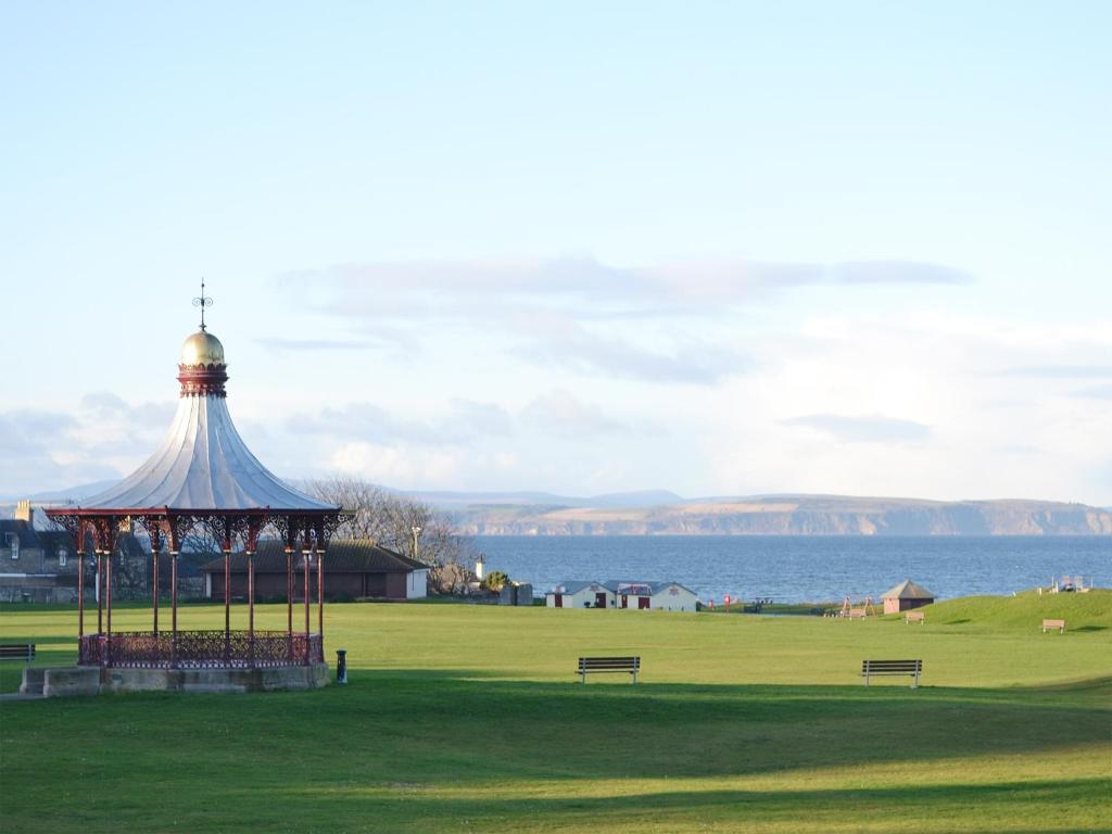 a gazebo in a park next to the water at Dolphin Cottage in Nairn