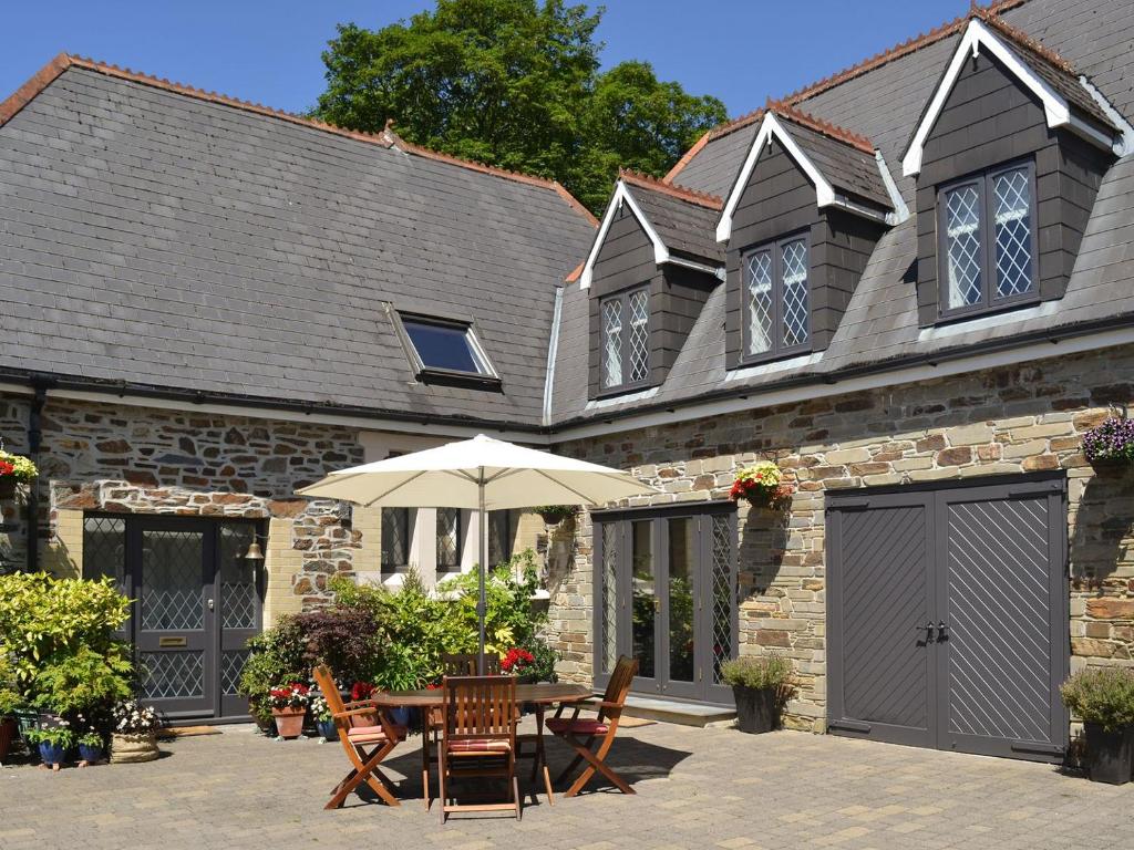 una mesa con sombrilla frente a un edificio en Old Church School, en Plympton