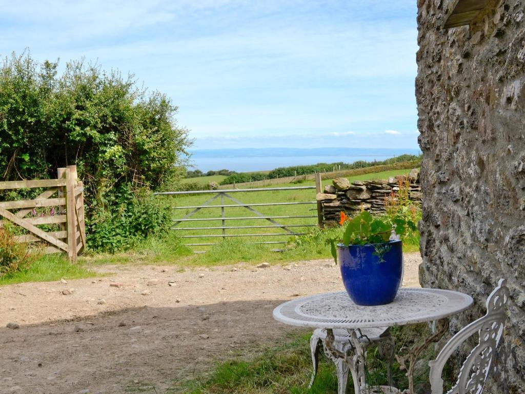 a blue pot sitting on a table next to a stone wall at Bats Roost - Hkkp in Lynton