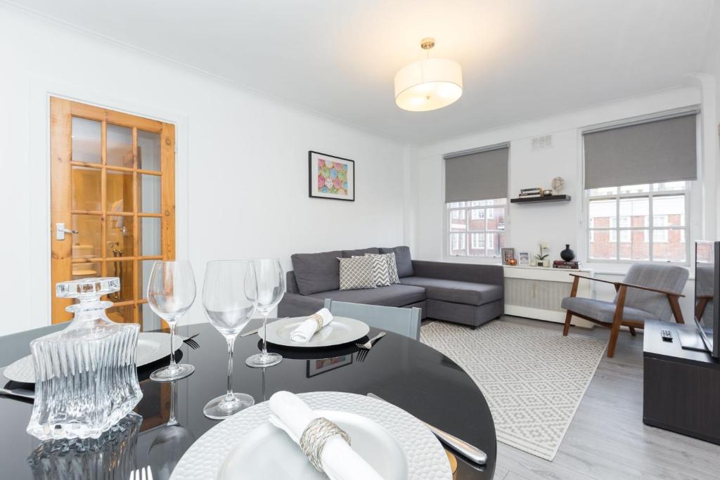 una sala de estar con una mesa y copas de vino en Urban Hyde Park One-Bedroom Retreat, en Londres