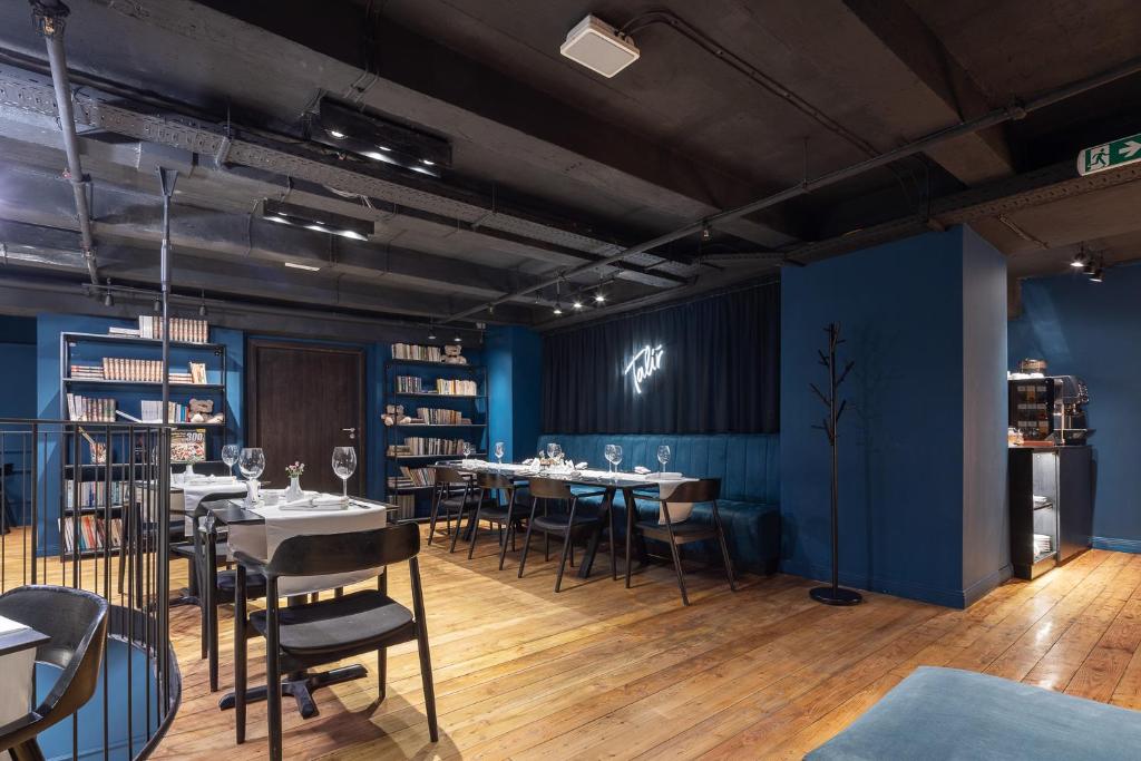 a dining room with tables and chairs and blue walls at Pytloun Boutique Hotel Prague in Prague