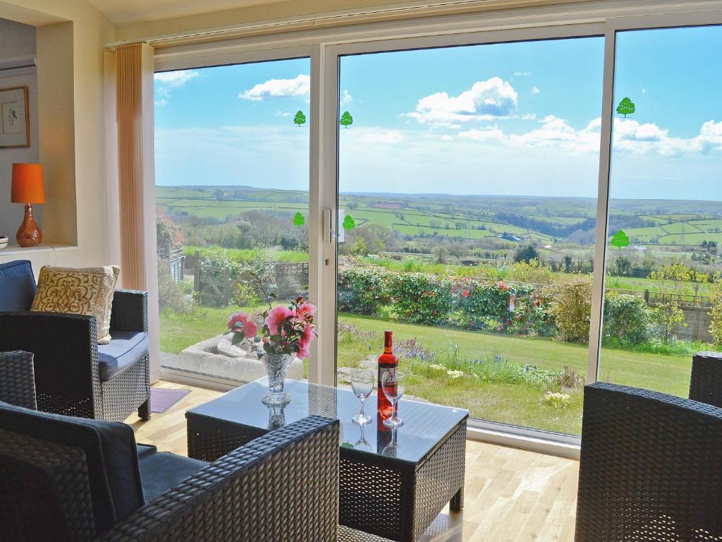 a living room with a view of the countryside through a large window at Beacon Cottage in Ivybridge