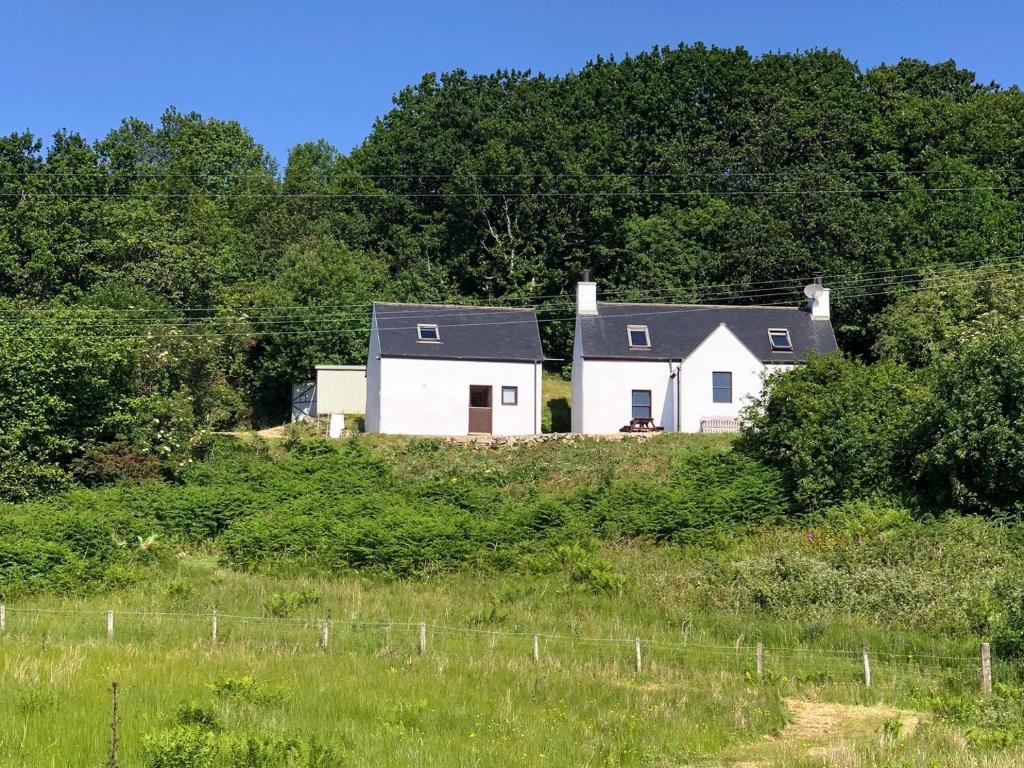 a house on top of a hill with trees at The Croft in Isleornsay