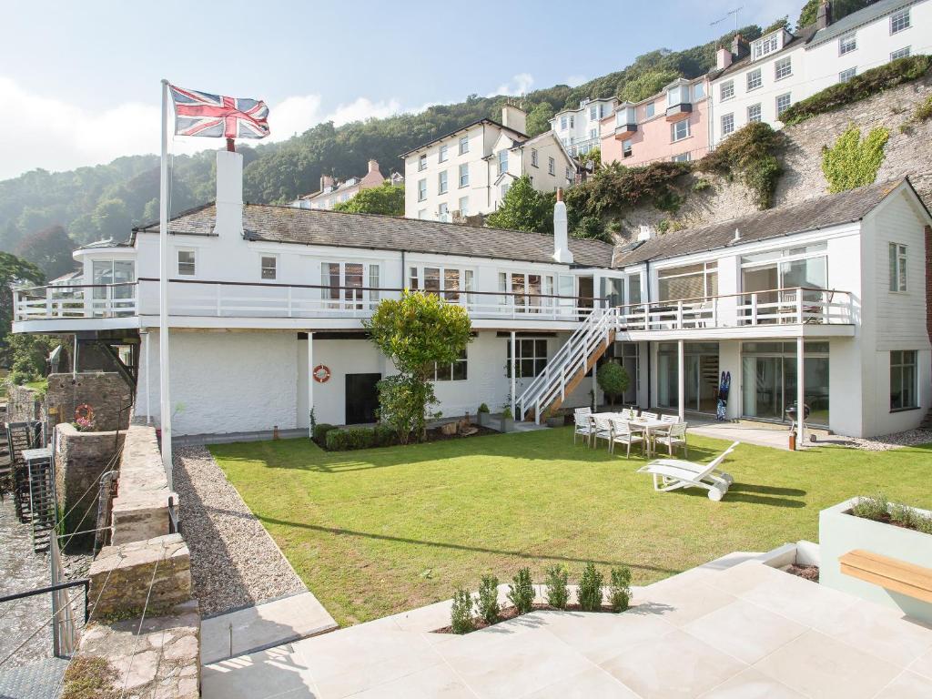 una gran casa blanca con una bandera encima en The Boathouse, en Dartmouth