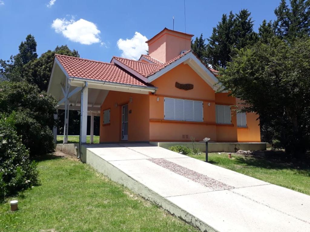 a small orange house with a driveway at Casa Naranja in Merlo