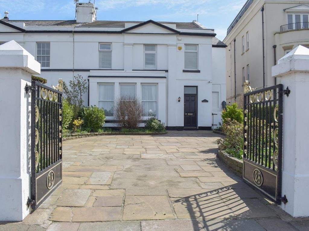 a white house with a gate and a driveway at Sandfield The Promenade in Southport