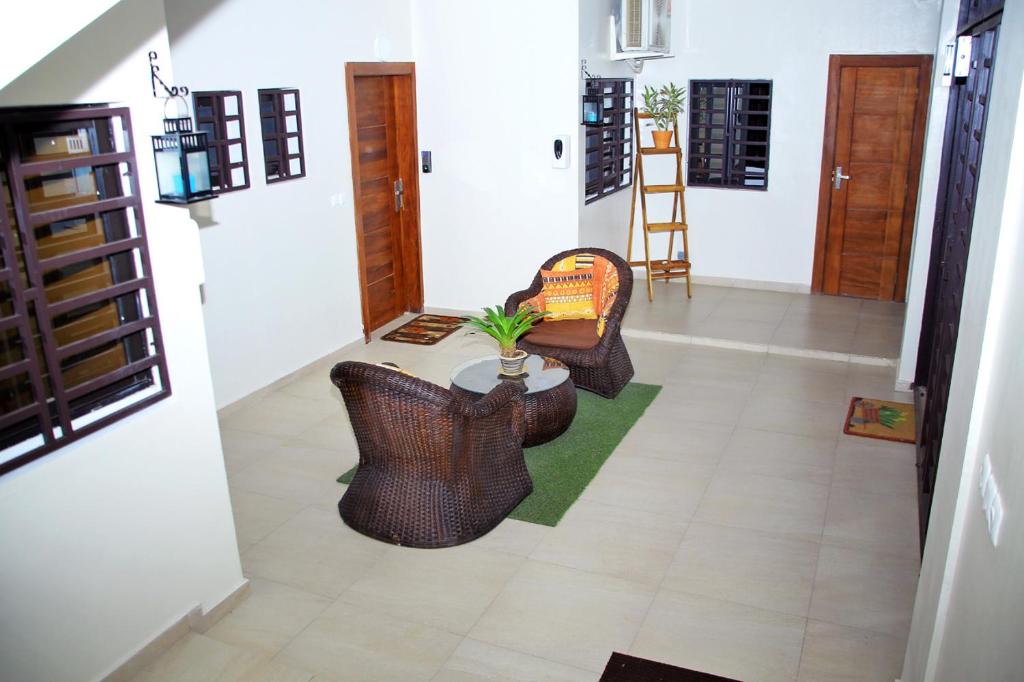 a living room with two chairs and a table at Appartement meublé 2 pièces rez de chaussée, Résidence Nehemie in Abidjan