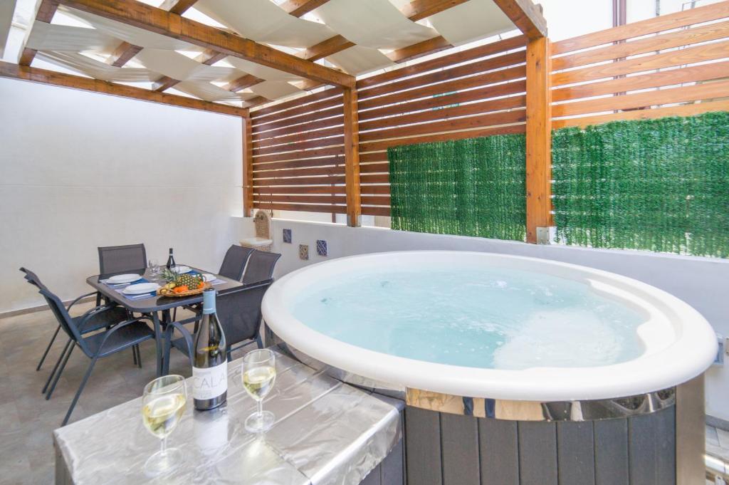 een groot bad in een kamer met een tafel en wijnglazen bij Al Mare in Porto Palo