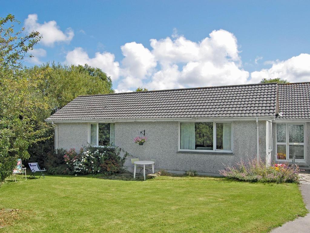 a white house with a yard with a house at Trewithen Farm Bungalow in St Merryn