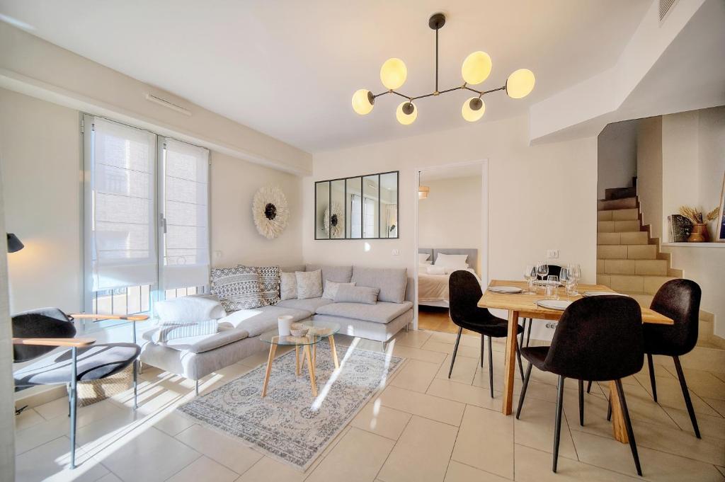 ein Wohnzimmer mit einem Sofa, einem Tisch und Stühlen in der Unterkunft Magnifique et lumineux 3 pieces A2B238 in Cannes
