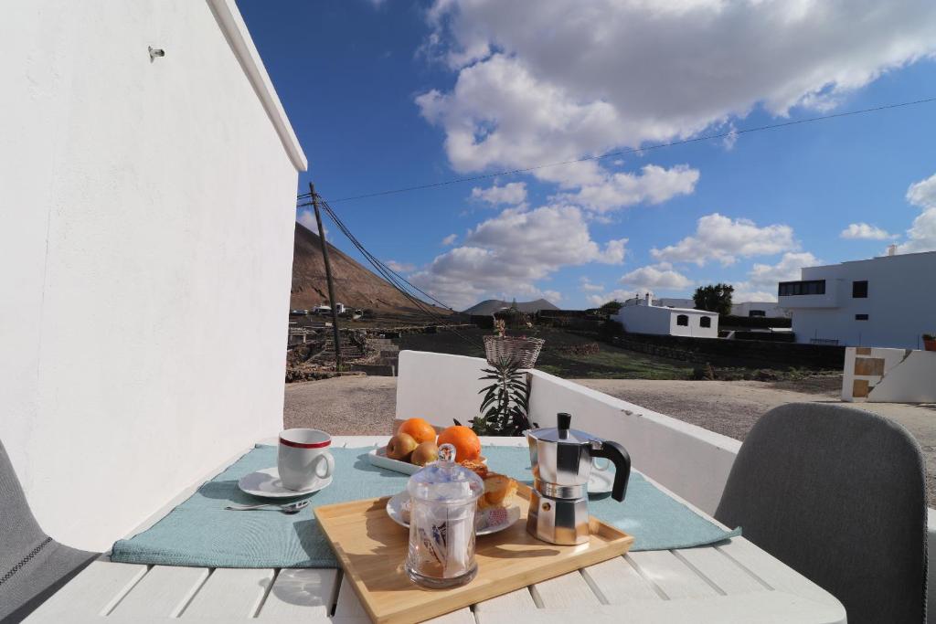 een tafel met een koffiezetapparaat en fruit op een balkon bij CASA los senderos in Tinguatón