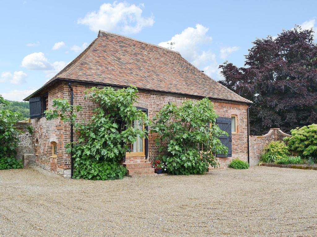 a brick house with two vines growing on it at Fig Cottage in Brabourne