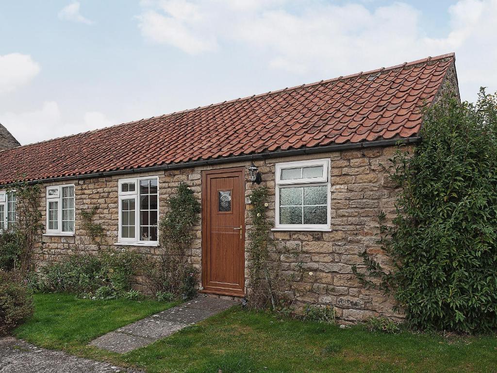 EbberstonにあるPeartree Farm Cottages - Rchm39の茶色のドアと窓のある石造りの家