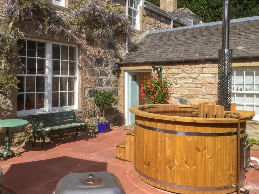 a large wooden barrel sitting in front of a house at The Mews in Insch