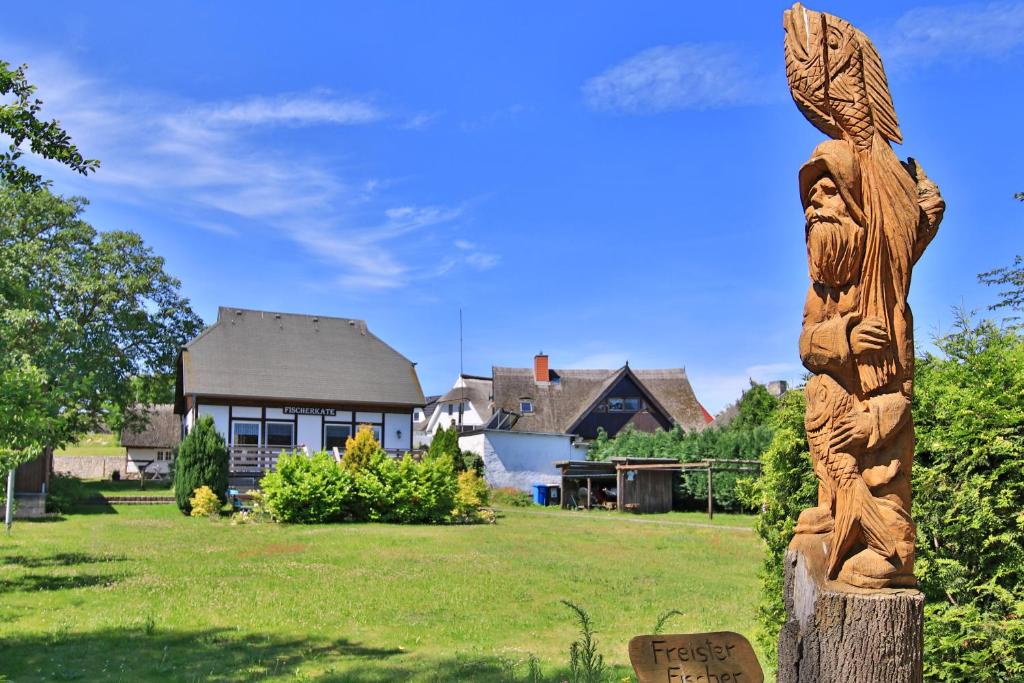 a wooden statue in front of a house at Fischerkate Freest in Freest