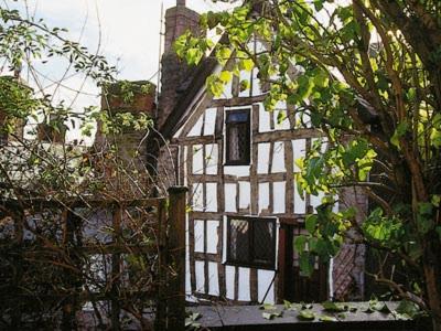 una casa vieja con una valla delante de ella en Mollys Cottage, en Knighton