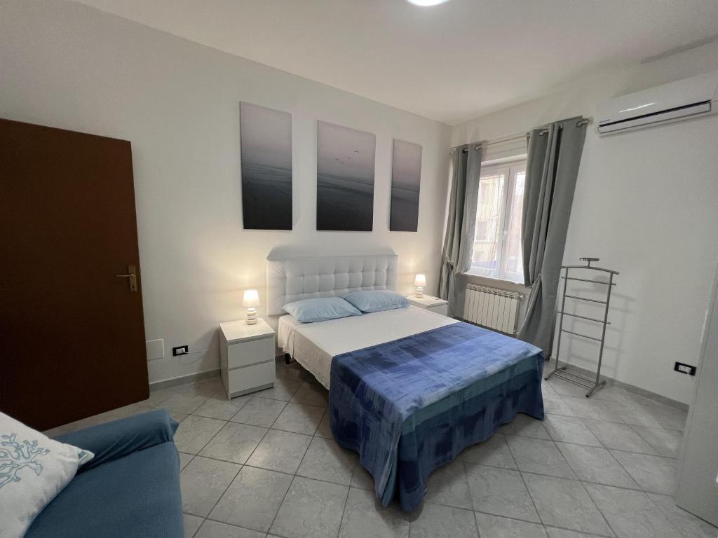 1 dormitorio con 1 cama, 2 mesas y 1 sofá en Bed and Breakfast Mare Blu, en Civitavecchia