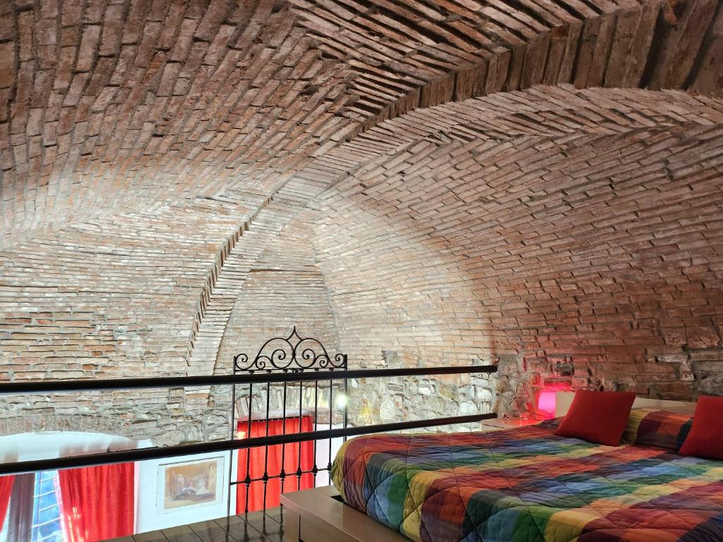 Pokój z łóżkiem w ceglanej ścianie w obiekcie Comfort Accommodation Loft w Bergamo