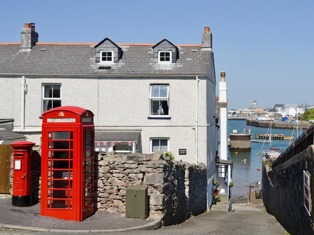a red phone booth in front of a building at Providence Cottage in Turnchapel