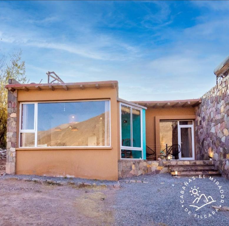 a house with a large window on the side of it at Cabañas El Mirador de Tilcara in Tilcara