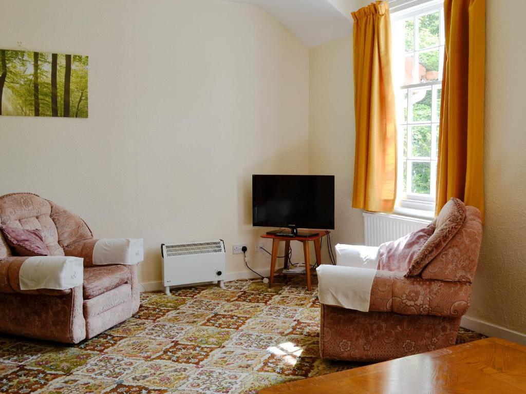 sala de estar con 2 sillas y TV de pantalla plana en Strathisla, en Largs