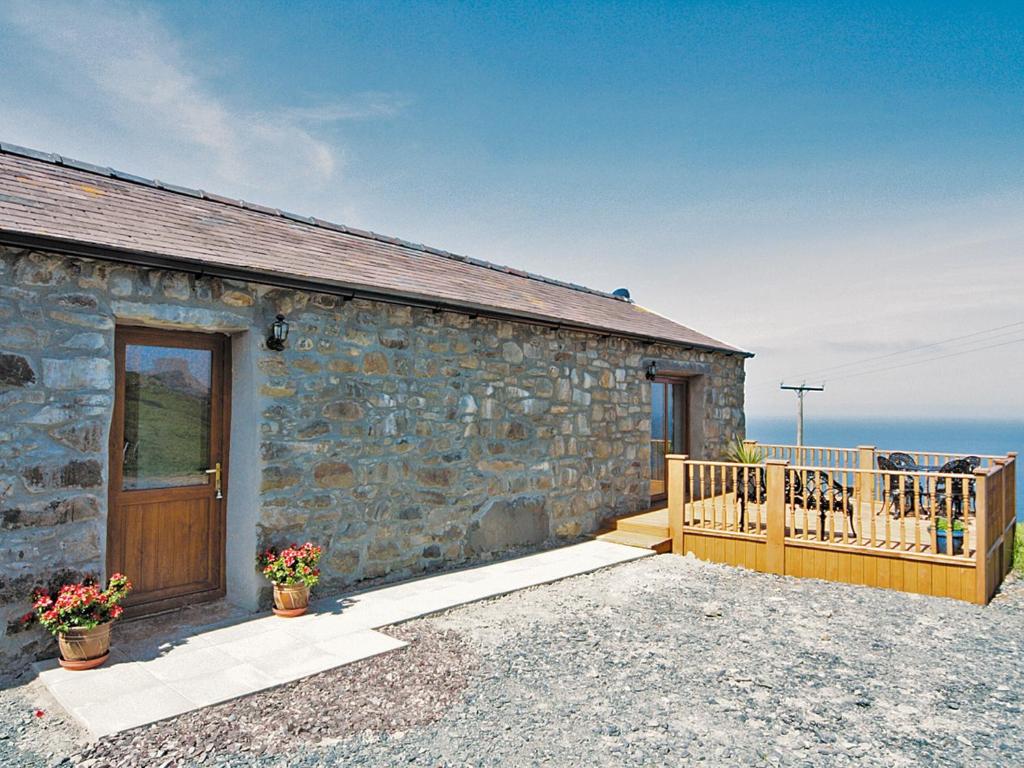 a stone cottage with a wooden door and a balcony at Ciliau Isaf - Hw7680 in Pistyll