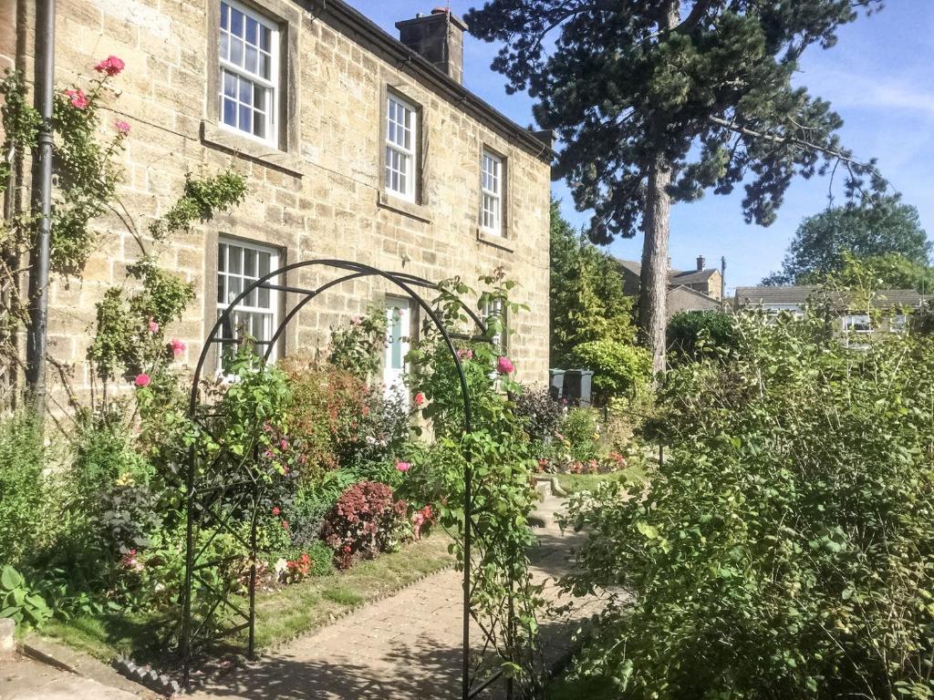 un jardín frente a una casa de piedra en Linden Cottage - E2549, en Matlock