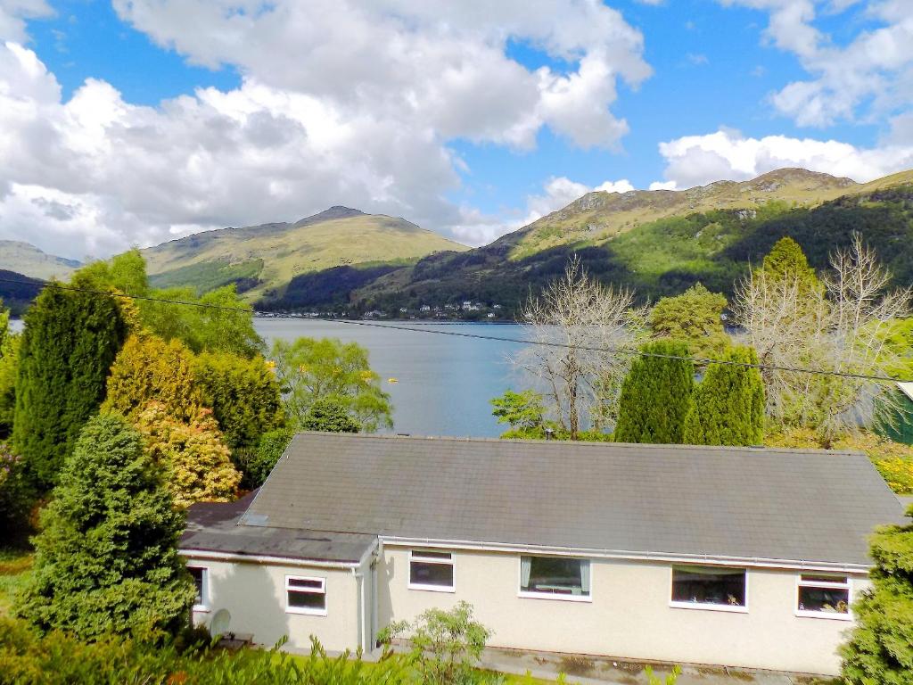 a house with a view of a lake and mountains at Feaugh Cottage in Lochgoilhead