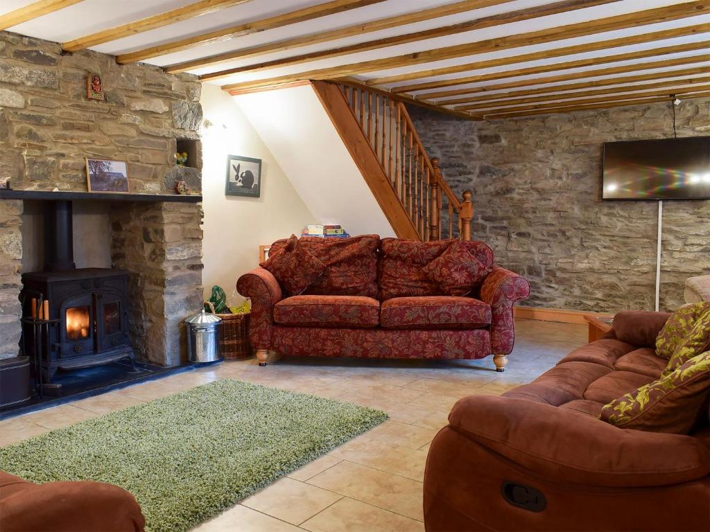 a living room with a couch and a fireplace at Penrhiw in Llangeitho