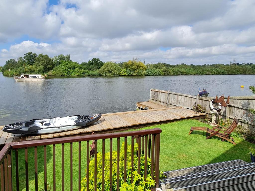 a boat is sitting on a dock on a lake at Herons View - 28279 in Brundall