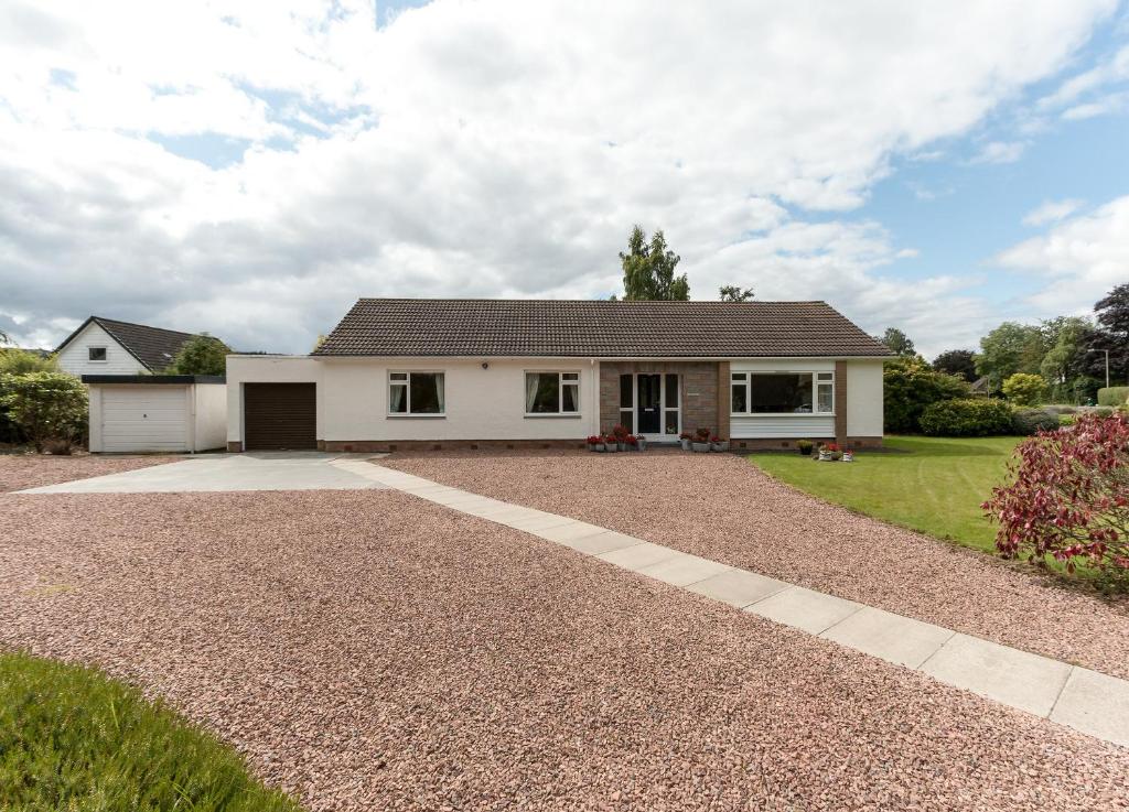 a house with a gravel driveway in front of it at Sheeoch in Comrie
