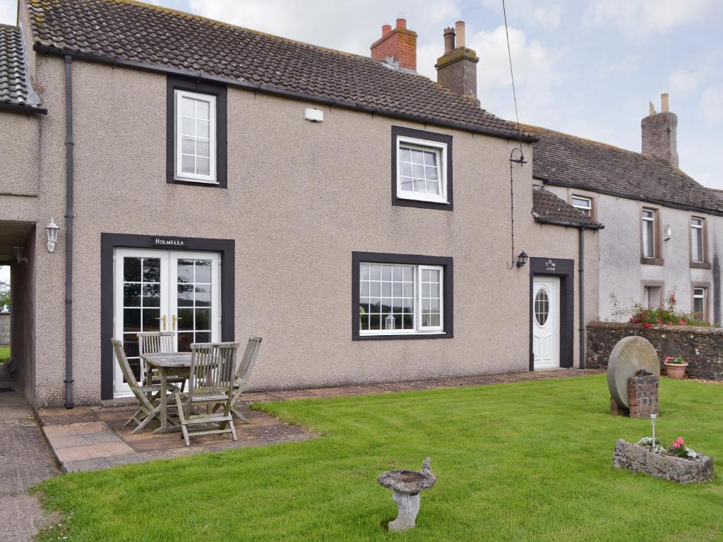 a house with a table and chairs in a yard at Holmlea in Beckfoot