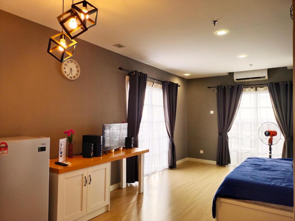 a bedroom with a bed and a desk and a clock at Kampar Champs Elysees, King Bed Studio unit 12A21 in Kampar