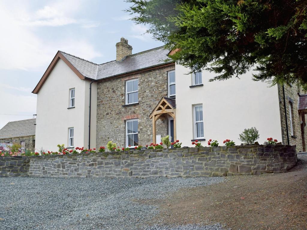 a large white house with a stone wall at The Sycamores in Clynderwen