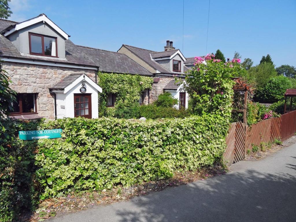 a house with a green hedge in front of it at Oakleigh Cottage in Llangelynin