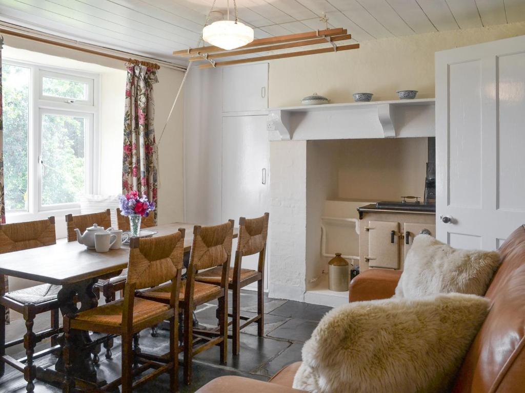 een woonkamer met een tafel en een bank bij Winscott Cottage in Pyworthy