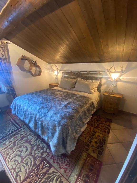 a bedroom with a bed with a blue comforter at Casa Gran Paradiso in Cogne