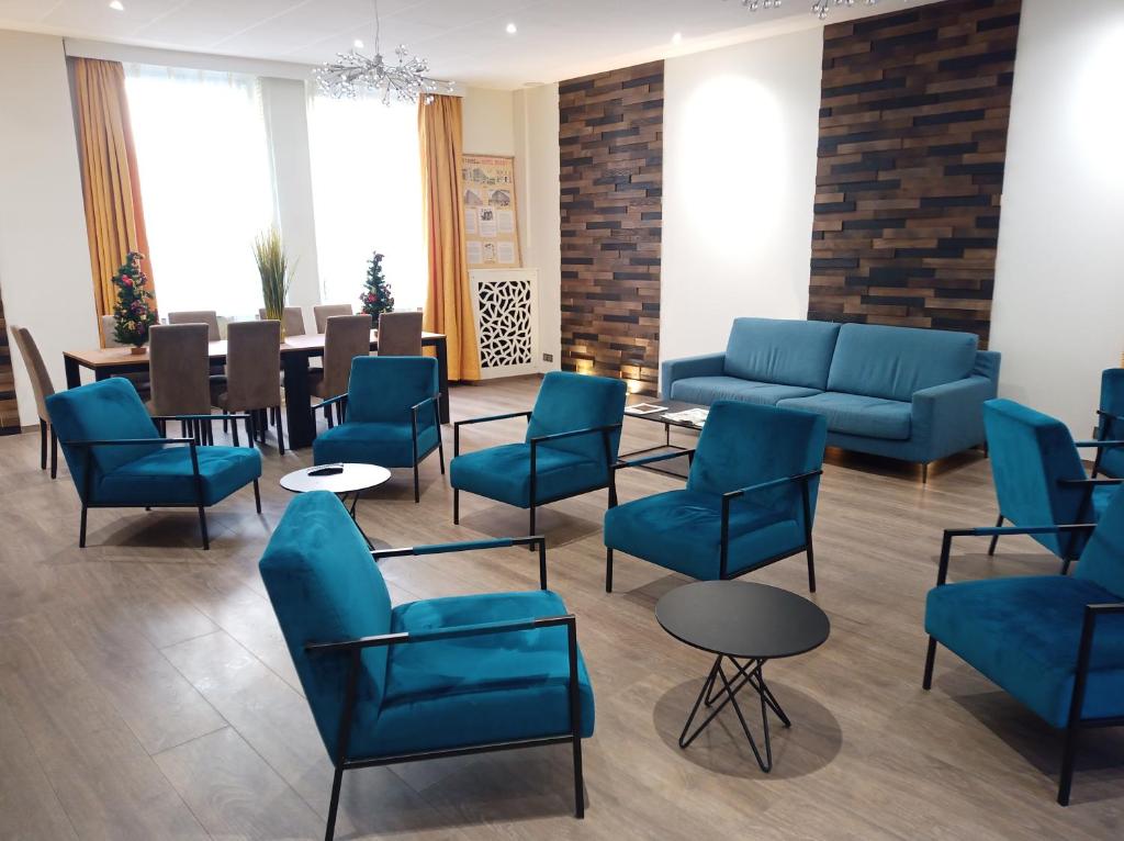 una sala de espera con sillas azules y una mesa en Hotel Busby, en Niza