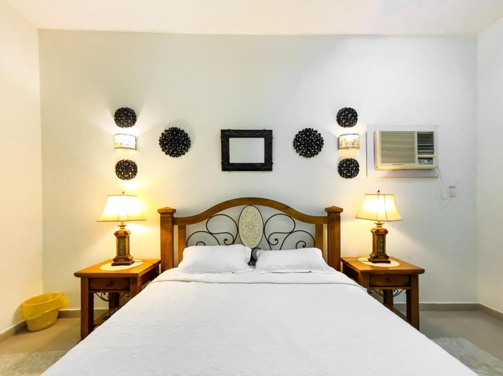 a bedroom with a white bed with two lamps at SHAIKHA villa in Umm al ‘Amad