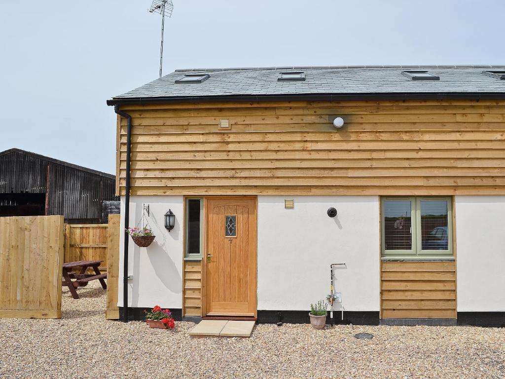 a smallshed with a white and brown building at The Hayloft - 28836 in Royal Wootton Bassett