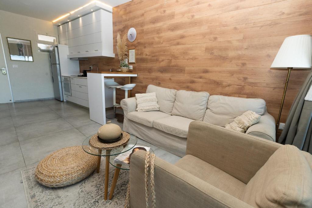 ein Wohnzimmer mit einem Sofa und einer Küche in der Unterkunft Neot Golf, Ziv's Place in Caesarea