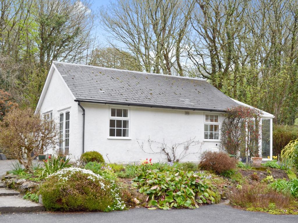 a white house with a garden in front of it at The Little House in Chacewater