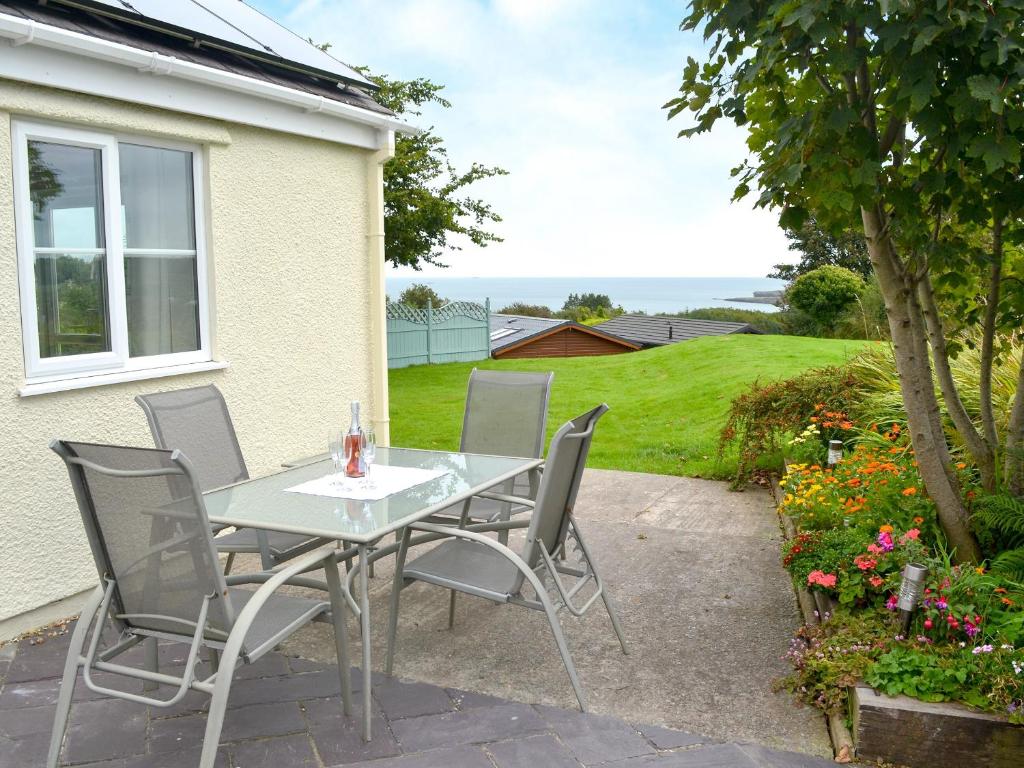 a table and chairs on the patio of a house at The Cottage in Penrhos-Lligwy
