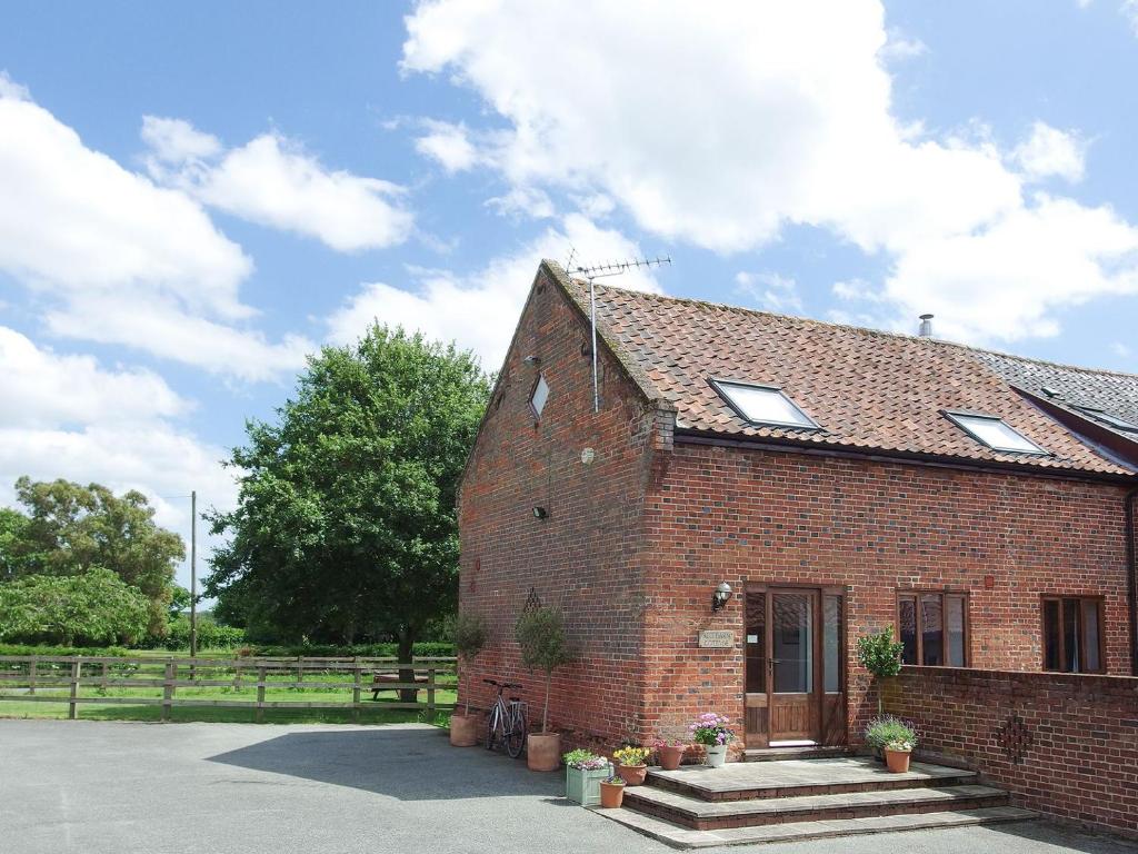 un edificio de ladrillo rojo con ventanas. en Red Barn Cottage, en Kettleburgh