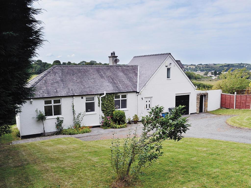 una casa bianca con vialetto e cortile di Grey Cottage a Pentraeth