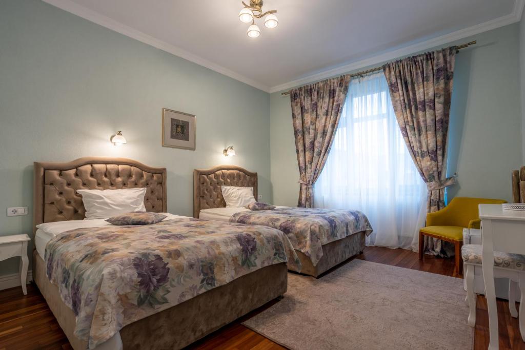 a bedroom with two beds and a window at Vila Missy in Deva