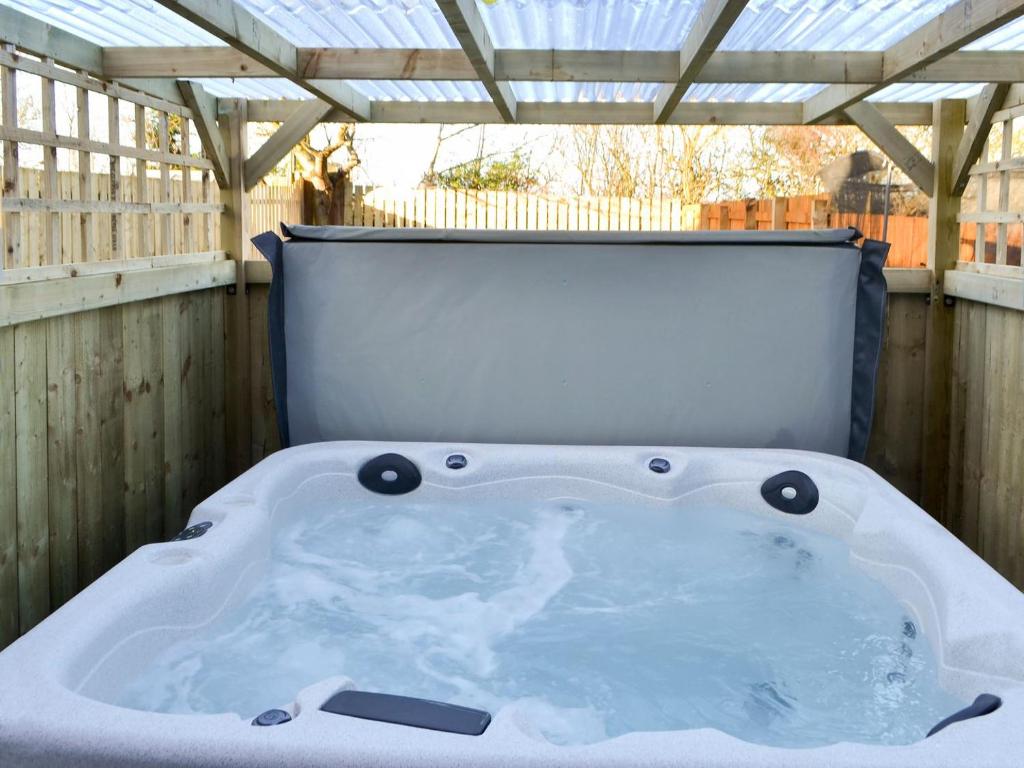 a hot tub sitting on the back of a deck at Seashells By The Sea in Newbiggin-by-the-Sea