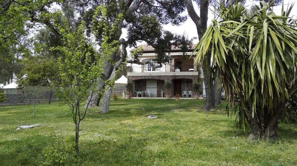 une maison au milieu d'une cour arborée dans l'établissement Le gite la licorne, à Saint-Raphaël