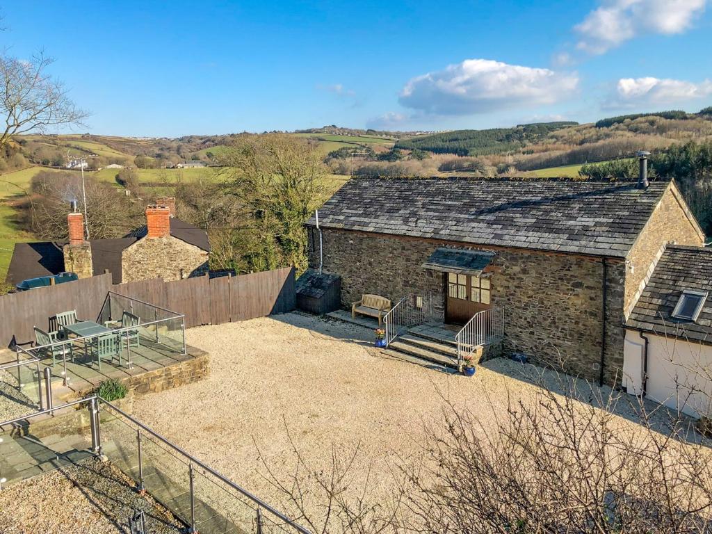 a stone house with a patio and a fence at Woods Close -17381 in Kilkhampton